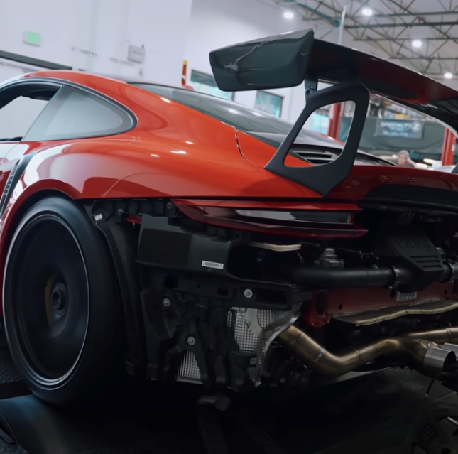 the rear end of a porsche 911 gt3 in a garage.